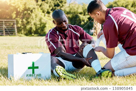 First aid, sport and black man with medic after an accident, knee pain and rugby injury. Healthcare, help and African athlete crying after a hurt muscle in sports with a doctor for medical attention First aid, sport and black man with medic after an accident, knee pain and rugby injury. Healthcare, help and African athlete crying after a hurt muscle in sports with a doctor for medical attention 138905845