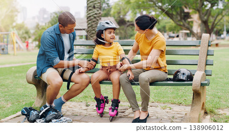 Family, rollerskate and interracial parents help kid with safety pads teaching her skating at the park and bonding outdoors. Mother, father and daughter learning to skate from mom and dad 138906012