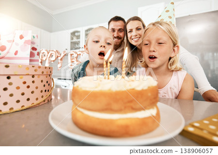 Birthday, cake and celebration with a girl and her sister blowing out candles and making a wish with her family in the background. Celebrating, party and growing up with children and their parents 138906057