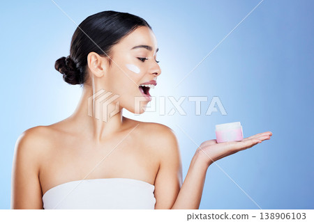 Woman, face and surprise for skincare moisturizer, cosmetics or beauty against a blue studio background. Portrait of happy female shocked with product, lotion or cream for facial treatment on mockup Woman, face and surprise for skincare moisturizer, cosmetics or beauty against a blue studio background. Portrait of happy female shocked with product, lotion or cream for facial treatment on mockup 138906103