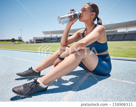Water, fitness and athlete at a stadium for training, exercise and workout for a professional event. Thirsty, hydration and woman with a drink after running, cardio performance and sport competition Water, fitness and athlete at a stadium for training, exercise and workout for a professional event. Thirsty, hydration and woman with a drink after running, cardio performance and sport competition 138906311