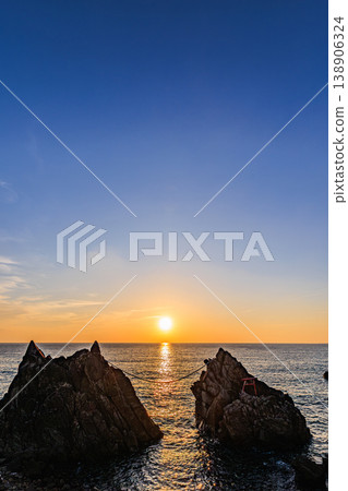 夕陽西下，映照著海面，雄龍和雌龍的輪廓在岩石間若隱若現。 138906324