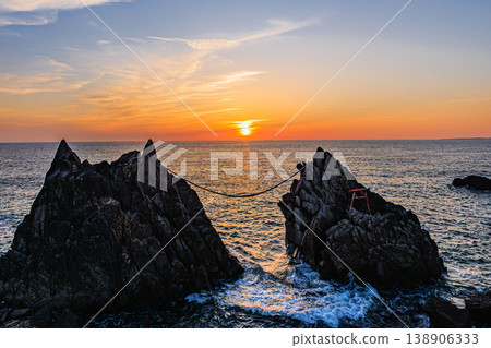 A contrasting landscape of the male and female dragon rocks against the setting sun. 138906333