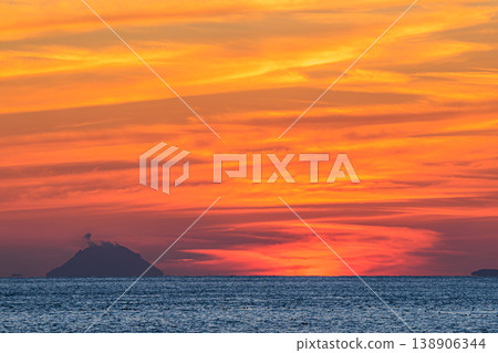 The silhouette of Iwo Jima and the sea ablaze with the setting sun. The silhouette of Iwo Jima and the sea ablaze with the setting sun. 138906344