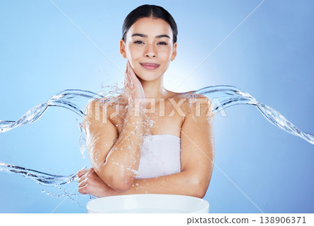 Water splash, skin care and portrait of woman with natural glow results on blue background. Face of aesthetic model person with facial, beauty cosmetic or hygiene for health, wellness and dermatology Water splash, skin care and portrait of woman with natural glow results on blue background. Face of aesthetic model person with facial, beauty cosmetic or hygiene for health, wellness and dermatology 138906371