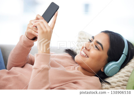 Phone, music and relaxation with a young woman lying down, resting and streaming songs online. Enjoying free time, relaxing and resting over the weekend at home. Browsing social media on the internet Phone, music and relaxation with a young woman lying down, resting and streaming songs online. Enjoying free time, relaxing and resting over the weekend at home. Browsing social media on the internet 138906538