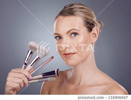 Face, tools for makeup and woman in portrait, beauty and skin glow with facial and foundation on studio background. Powder, cosmetics brush and skincare with shine, cosmetology and cosmetic care 138906697