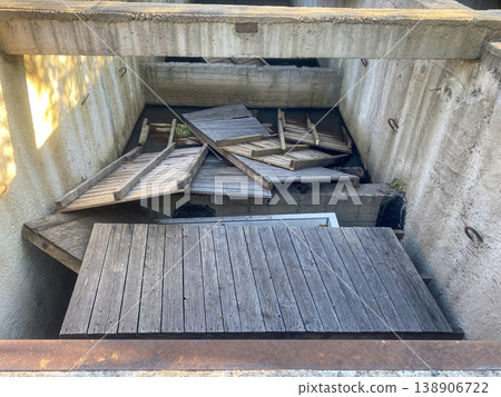 Wooden boards and debris stacked in an open structure during daytime at a construction site Wooden boards and debris stacked in an open structure during daytime at a construction site 138906722