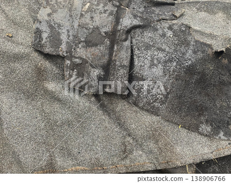 Old roofing material lies on the ground during a renovation project in an urban area in summer 138906766