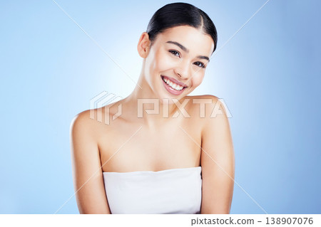 Skincare, beauty and portrait of young woman with makeup and face cleaning in studio. Happy, cosmetics and facial wellness of female with self care and cosmetic treatment in isolated blue background Skincare, beauty and portrait of young woman with makeup and face cleaning in studio. Happy, cosmetics and facial wellness of female with self care and cosmetic treatment in isolated blue background 138907076