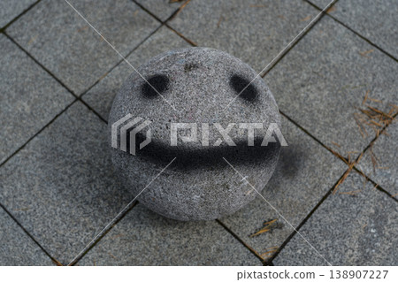 A stone ball with a face painted on it. Smiley face A stone ball with a face painted on it. Smiley face 138907227