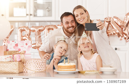 Family birthday party in kitchen, mom photograph on phone camera for social media and mother and father celebrate. Gifts, cake, food and foil balloons at home with dad and twin sisters. 138907289