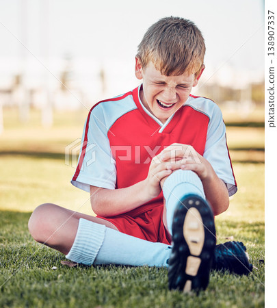 Soccer, knee injury and pain on a field after match, training or fitness exercise at stadium pitch. Sports, football and boy in a medical emergency with torn muscle, sprain or broken bone in his leg. Soccer, knee injury and pain on a field after match, training or fitness exercise at stadium pitch. Sports, football and boy in a medical emergency with torn muscle, sprain or broken bone in his leg. 138907337
