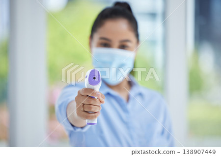 Hand, woman employee and covid thermometer laser for medical exam, check or covid 19 scan at office. Healthcare worker, mask and scan for corona virus safety and wellness protection at a workplace Hand, woman employee and covid thermometer laser for medical exam, check or covid 19 scan at office. Healthcare worker, mask and scan for corona virus safety and wellness protection at a workplace 138907449
