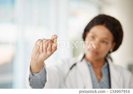 Medical doctor with medicine pills in hand while working in a hospital or clinic. Woman healthcare professional or expert showing oil capsule, vitamin or omega 3 supplement in hospital or pharmacy 138907958