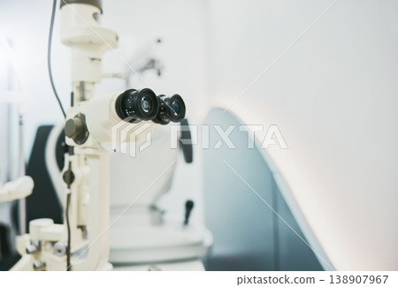 Ophthalmology machine, eye care and interior for medical healthcare, wellness or vision in clinic office. Optometrist consultation room, help or technology for digital equipment by blurred background 138907967