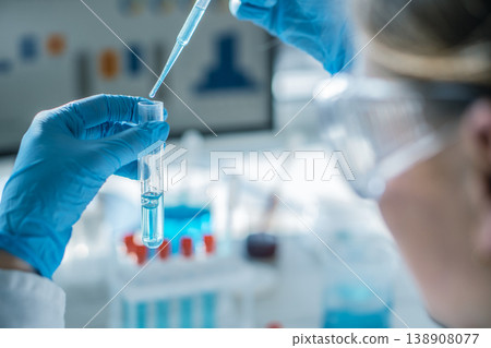 Closeup of laboratory technician performing precise experiment with pipette and test tube, focusing on blue solution. Cutting edge science, healthcare, and pharmaceutical research environment depicted Closeup of laboratory technician performing precise experiment with pipette and test tube, focusing on blue solution. Cutting edge science, healthcare, and pharmaceutical research environment depicted 138908077