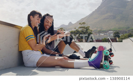Friends, phone and women relax after roller skate training in a skate park browsing social media trend on the internet. Online, connected and extreme sports people resting and laughing at meme Friends, phone and women relax after roller skate training in a skate park browsing social media trend on the internet. Online, connected and extreme sports people resting and laughing at meme 138908114