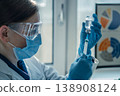 Doctor or nurse wearing blue gloves and lab coat fills syringe from glass vial, focusing on vaccination process. Modern healthcare and immunization concept in bright hospital environment 138908124