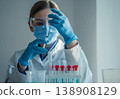 A laboratory scientist in safety gear carefully fills a syringe with a transparent solution for scientific analysis. The scene highlights advanced medical research and biotechnology innovation 138908129