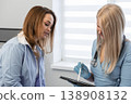 Healthcare professional in white coat, stethoscope discusses medical information with patient, utilizing tablet for digital documentation. Modern medical consultation, technology integration are 138908132