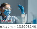 A researcher wearing gloves, goggles, and a face mask analyzes a chemical sample in a test tube. The laboratory setting emphasizes safety, innovation, and scientific discovery 138908140