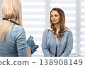 A female patient sits across from a doctor, engaging in a thoughtful conversation about her health in a bright, contemporary medical office. Trust and care are emphasized in this healthcare scene 138908149