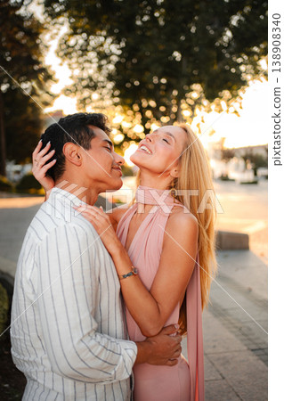 Romantic sunset embrace between two lovers in a park setting 138908340