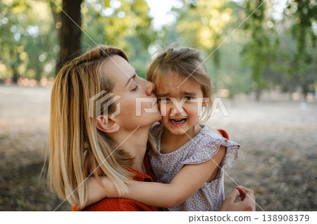 Mother comforting her crying daughter in a park 138908379