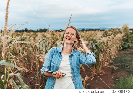 Farmer smiling and holding tablet in corn field 138908470
