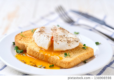 Poached egg with runny yolk and microgreens on a toasted bread for healthy breakfast . Healthy breakfast food concept. Poached egg with runny yolk and microgreens on a toasted bread for healthy breakfast . Healthy breakfast food concept. 138908598