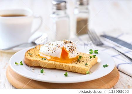 Poached egg with runny yolk and microgreens on a toasted bread for healthy breakfast . Healthy breakfast food concept. Poached egg with runny yolk and microgreens on a toasted bread for healthy breakfast . Healthy breakfast food concept. 138908603