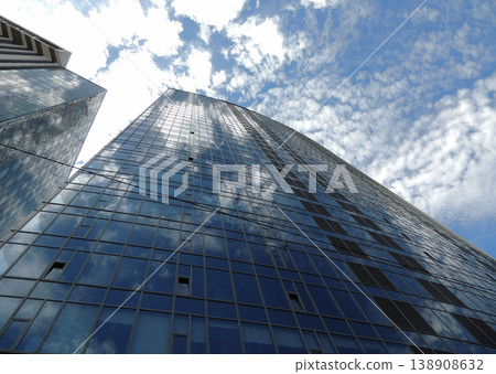 Bottom view of the glass office building with clouds reflection in windows 138908632