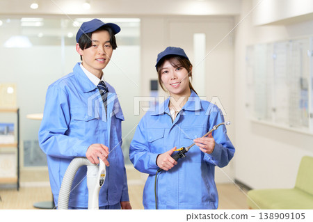 A man and a woman, cleaning experts who maintain the aesthetic appearance of office buildings. A man and a woman, cleaning experts who maintain the aesthetic appearance of office buildings. 138909105