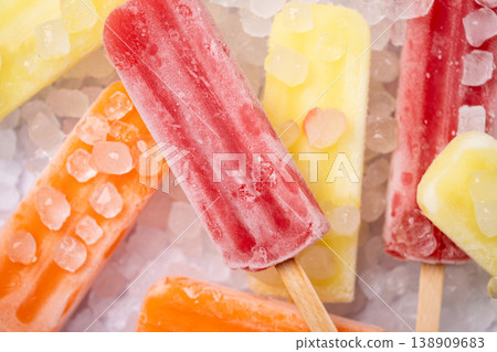 Colorful fruit popsicles on crushed ice Colorful fruit popsicles on crushed ice 138909683