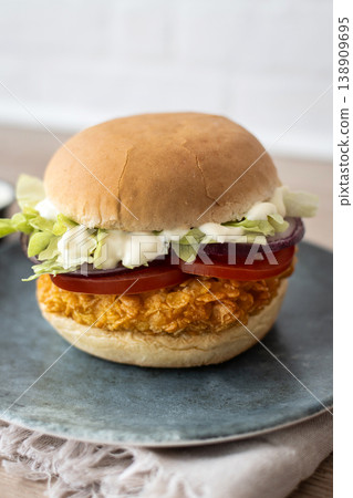 Crispy chicken burger on plate with lettuce tomato and sauce Crispy chicken burger on plate with lettuce tomato and sauce 138909695