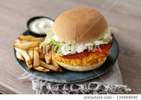 Crispy chicken burger with french fries and dipping sauce on plate Crispy chicken burger with french fries and dipping sauce on plate 138909696