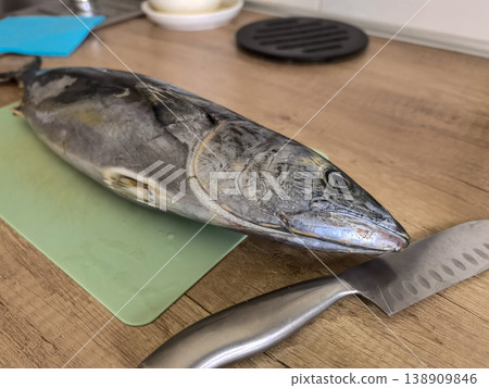 Whole Raw Fish on Cutting Board with Kitchen Knife 138909846