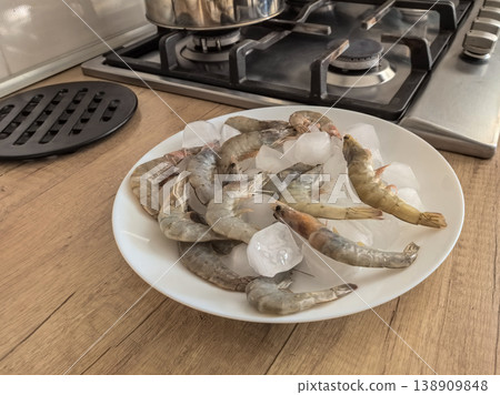 Raw Shrimp on Ice Plate in Kitchen Setting 138909848