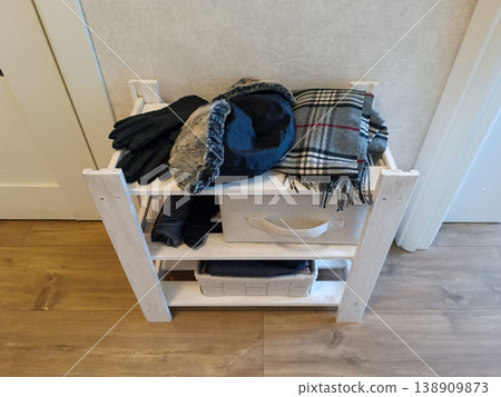 White Wooden Shelving Unit with Winter Clothes 138909873