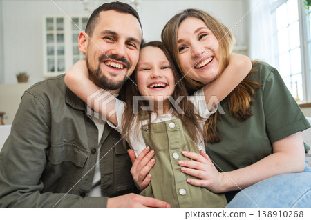 Happy family at home. Mother father children daughter relaxing on sofa indoor. Mom dad parents kid girl relax playing hugging having fun together. Family smiling laughing enjoying tender moment Happy family at home. Mother father children daughter relaxing on sofa indoor. Mom dad parents kid girl relax playing hugging having fun together. Family smiling laughing enjoying tender moment 138910268