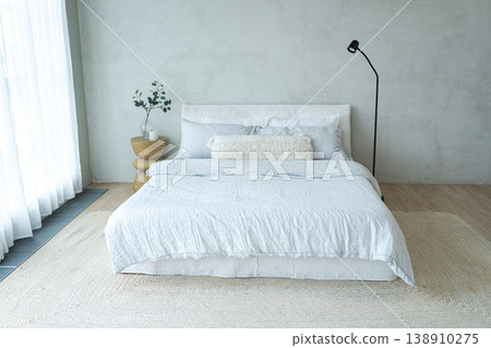 Stylish loft bedroom interior. Spacious design apartment with light walls large windows big bed. Clean modern decoration with elegant furniture in minimalist Scandinavian style 138910275
