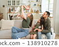 Happy family at home. Mother father two children daughters relaxing on sofa indoor. Mom dad parents baby girls kids relax playing having fun together. Family smiling laughing enjoying tender moment 138910278
