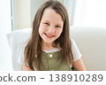 Happy girl at home. Smiling cute little brown haired Caucasian girl looking at camera. Portrait of happy female child at home. Smiling face of 10 year old girl looking at camera 138910289