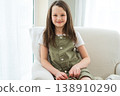 Happy girl at home. Smiling cute little brown haired Caucasian girl looking at camera. Portrait of happy female child at home. Smiling face of 10 year old girl looking at camera 138910290