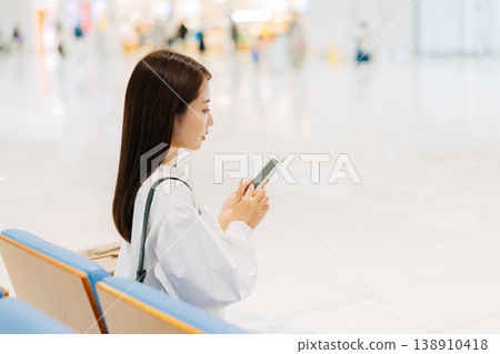 A woman relaxing in the airport lobby before departure. (Photo courtesy of Kansai International Airport (KIX)) A woman relaxing in the airport lobby before departure. (Photo courtesy of Kansai International Airport (KIX)) 138910418