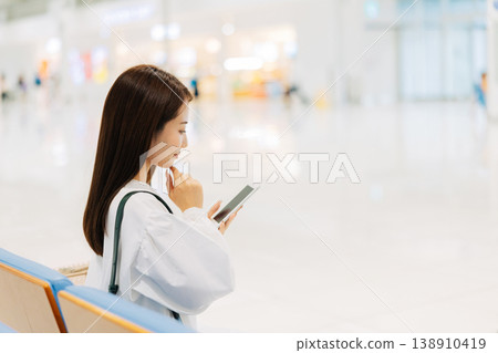 A woman relaxing in the airport lobby before departure. (Photo courtesy of Kansai International Airport (KIX)) A woman relaxing in the airport lobby before departure. (Photo courtesy of Kansai International Airport (KIX)) 138910419