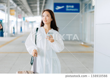 Woman looking at her smartphone at the airport. (Photo courtesy of Kansai International Airport (KIX)) Woman looking at her smartphone at the airport. (Photo courtesy of Kansai International Airport (KIX)) 138910566