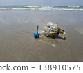 Ocean's Unwanted Guest: A weathered plastic bottle lies stranded on the sandy shore, a stark reminder of environmental pollution and the urgent need for conservation. 138910575