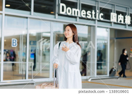 Woman holding a smartphone at the airport. "Photo courtesy of Kansai International Airport (KIX)" Woman holding a smartphone at the airport. "Photo courtesy of Kansai International Airport (KIX)" 138910601